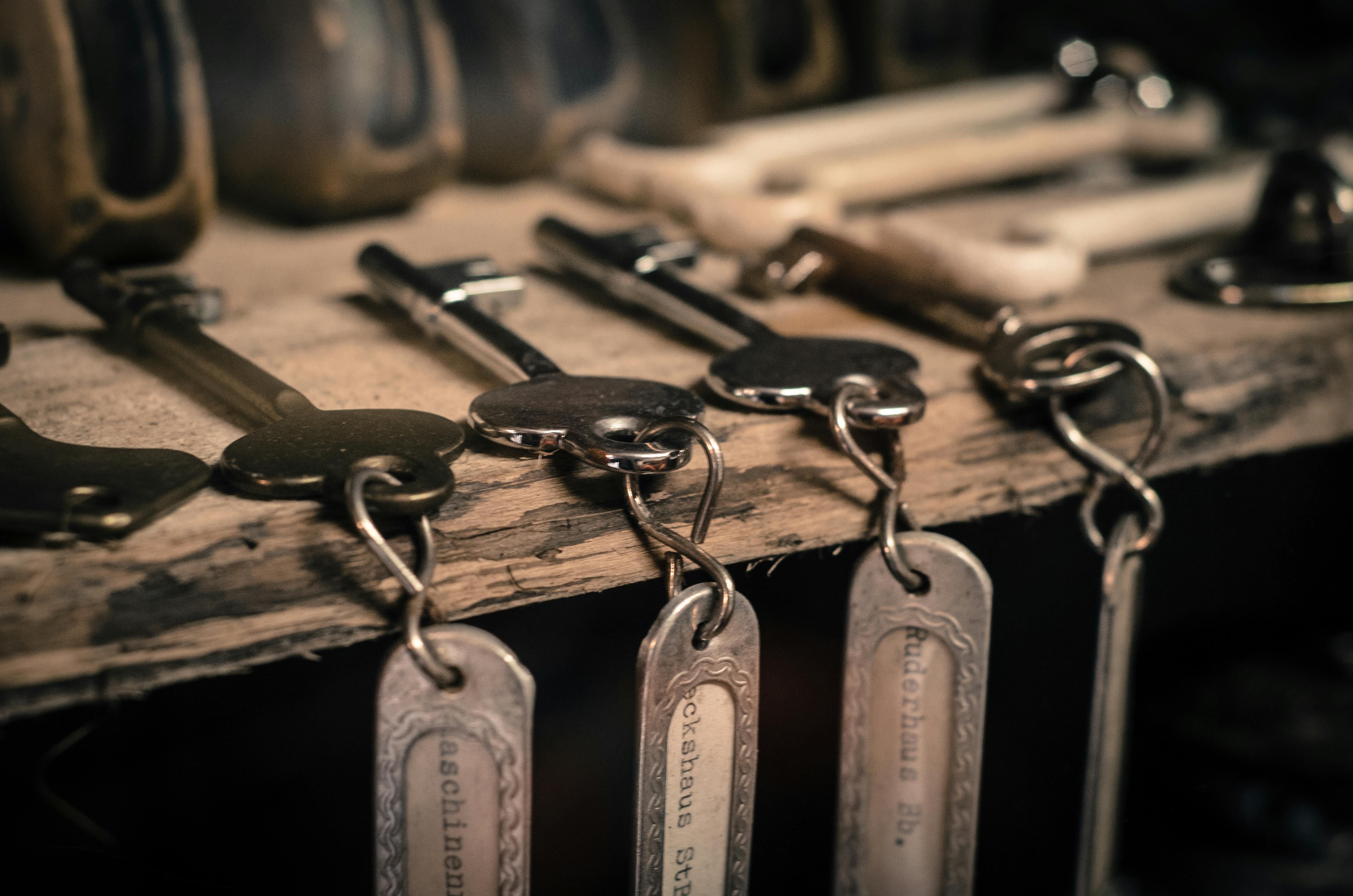 Professional locksmith tools and vintage keys on wooden surface
